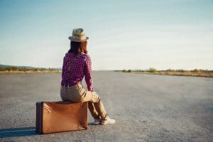 Woman with luggage waiting on the road