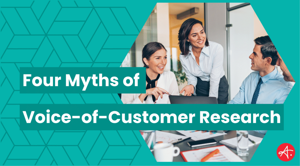 Three professionals collaborate and share ideas around a laptop in a bright modern office, symbolizing teamwork and insight. Text overlay reads: Four Myths of Voice-of-Customer Research.