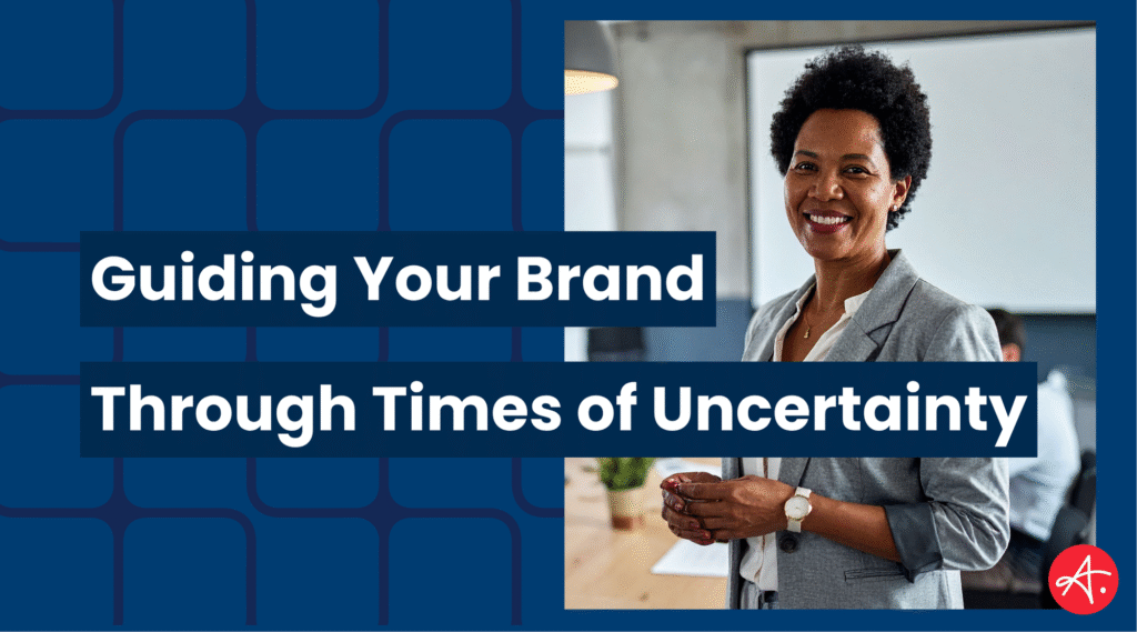 Confident business professional stands in a modern office with colleagues in the background, symbolizing leadership and stability. Text overlay reads: Guiding Your Brand Through Times of Uncertainty.