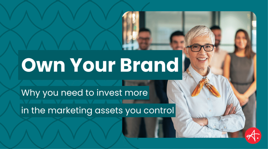 Confident business leader stands with arms crossed in front of a smiling team, symbolizing brand ownership and leadership. Text overlay reads: Own Your Brand – Why you need to invest more in the marketing assets you control.