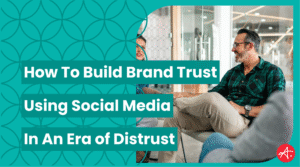 Business professionals having a casual meeting in a modern office, discussing how to build brand trust using social media. Text on image reads How To Build Brand Trust Using Social Media In An Era of Distrust.