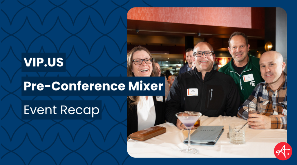 Four smiling professionals pose together at a cocktail bar during the VIP.US Pre-Conference Mixer, with drinks and a menu visible on the table in front of them.