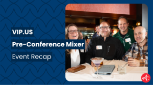 Four smiling professionals pose together at a cocktail bar during the VIP.US Pre-Conference Mixer, with drinks and a menu visible on the table in front of them.